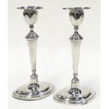 A pair of sterling silver hallmarked candlesticks each 18.5cm tall.