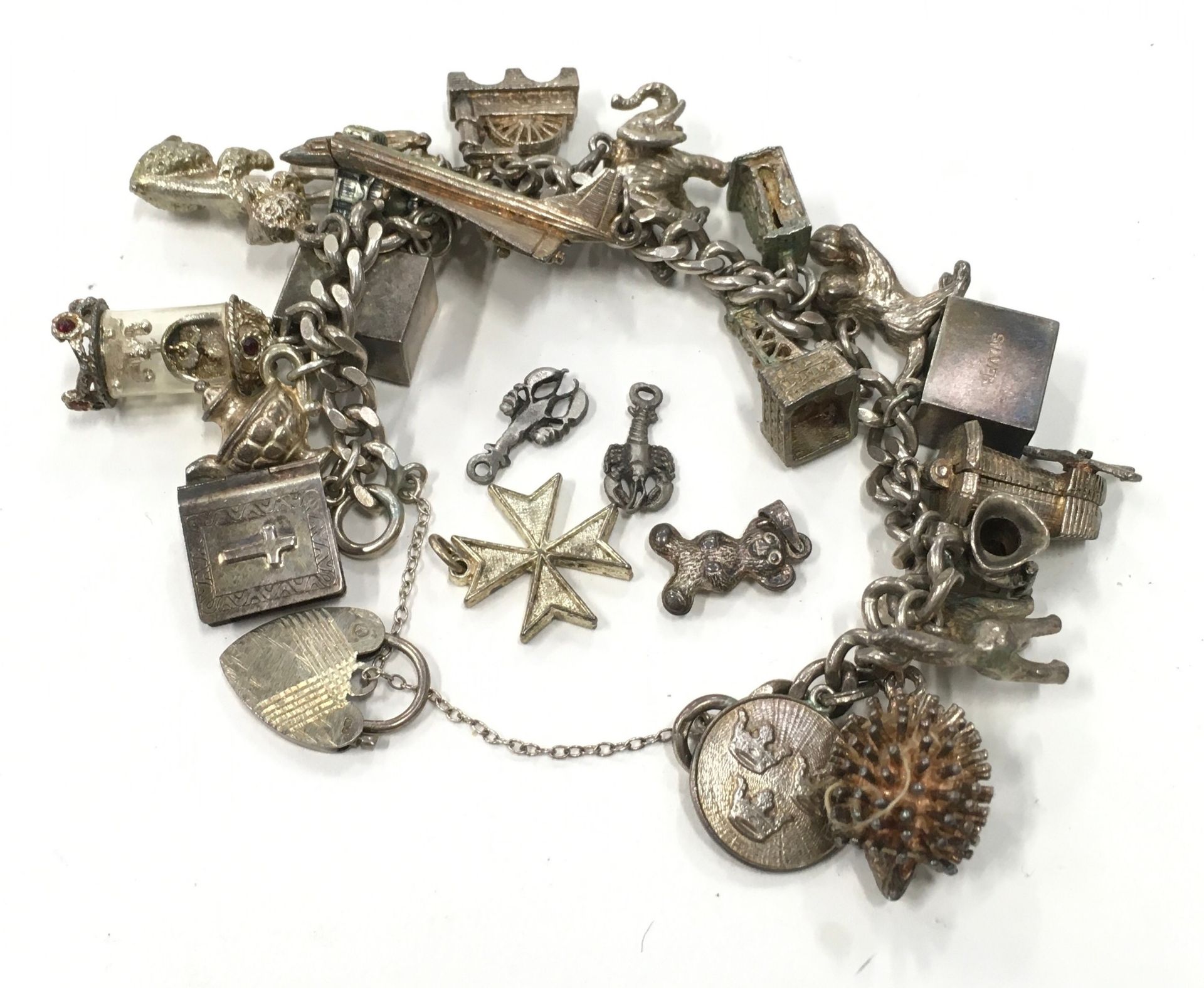 Silver charm bracelet with a large collection of charms.
