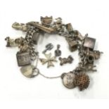 Silver charm bracelet with a large collection of charms.