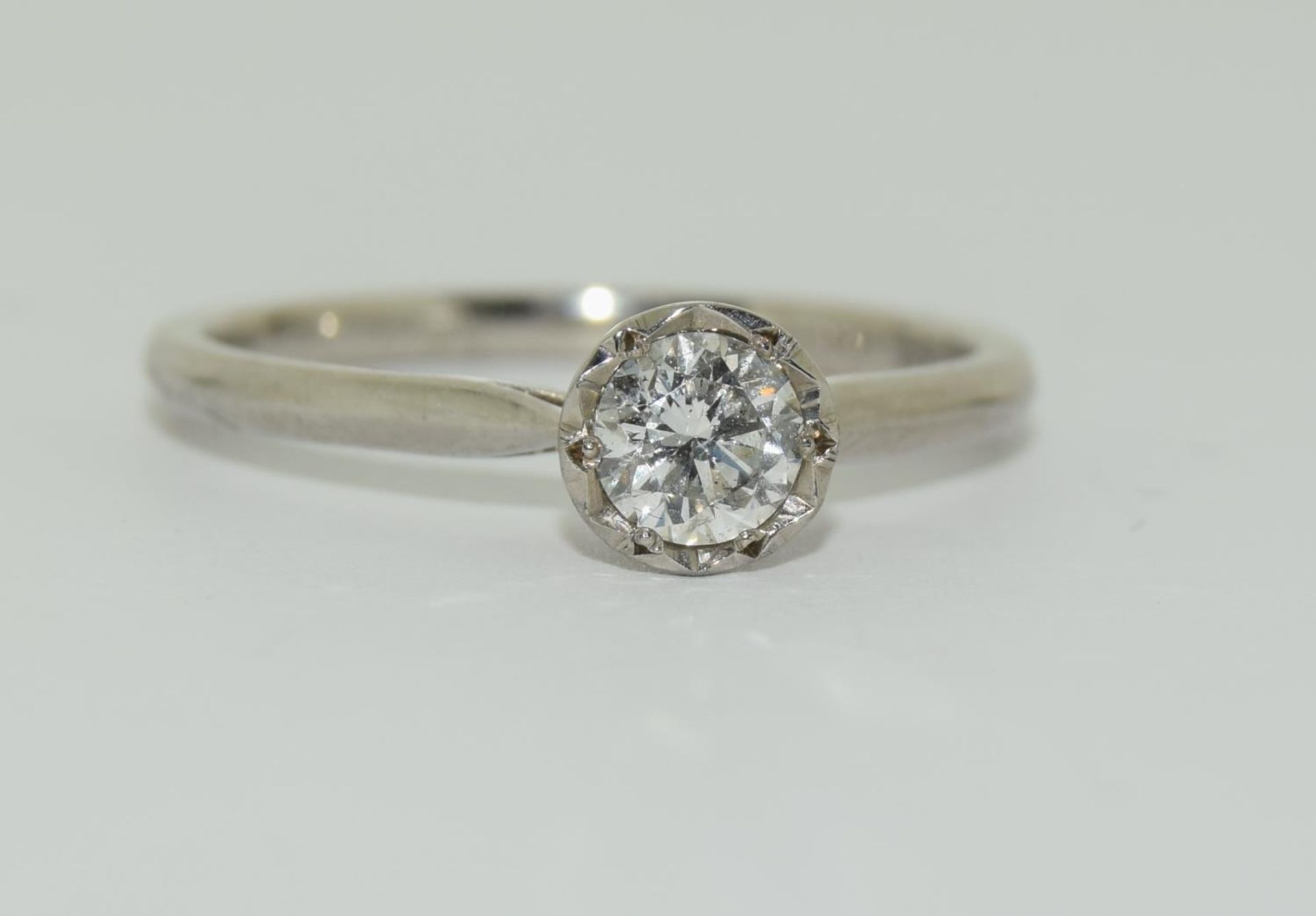 Palladium solitare diamond ring featuring a round brilliant cut diamond in an illusion setting of