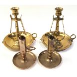 A pair of ships gimble brass candlesticks together with a pair of small brass night candle holders.