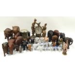 Large collection of elephant figurines together with three modern clocks.