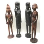 set of four large solid wood hand carved tribal figures, 2 male and 2 female, the largest being