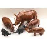 Collection of carved wooden rhinoceroses, 6 in all, the largest being 38cm across x 21cm tall