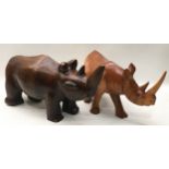 Pair of large solid wood carved rhinoceroses, the larger being 40cm across x 20cm tall