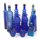 A collection of blue glassware to include vases and bottles.