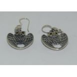 A pair of silver wings of peace earrings