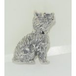 A silver dog brooch