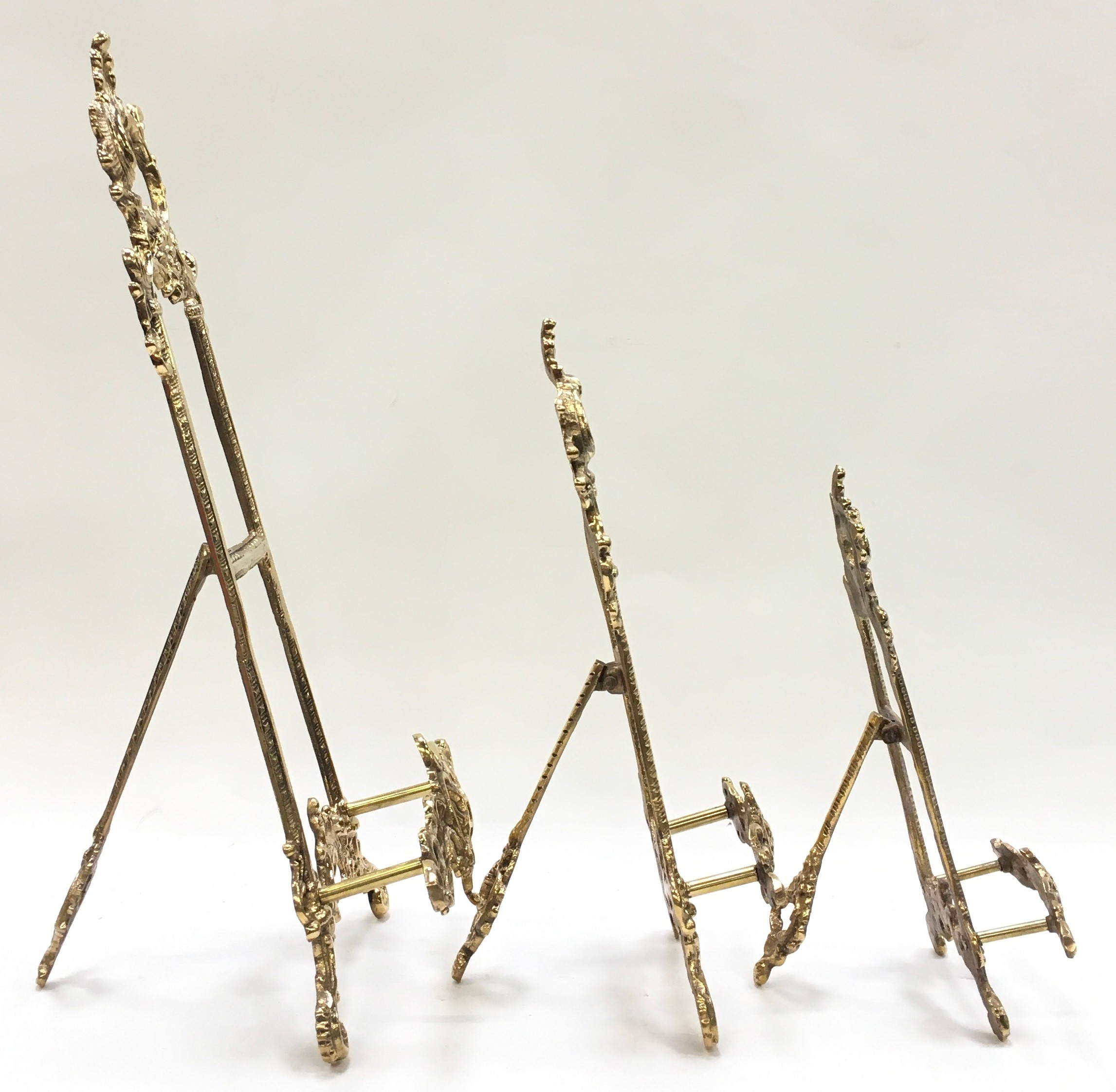 A set of three brass graduated easel back picture frame holders. - Image 2 of 3
