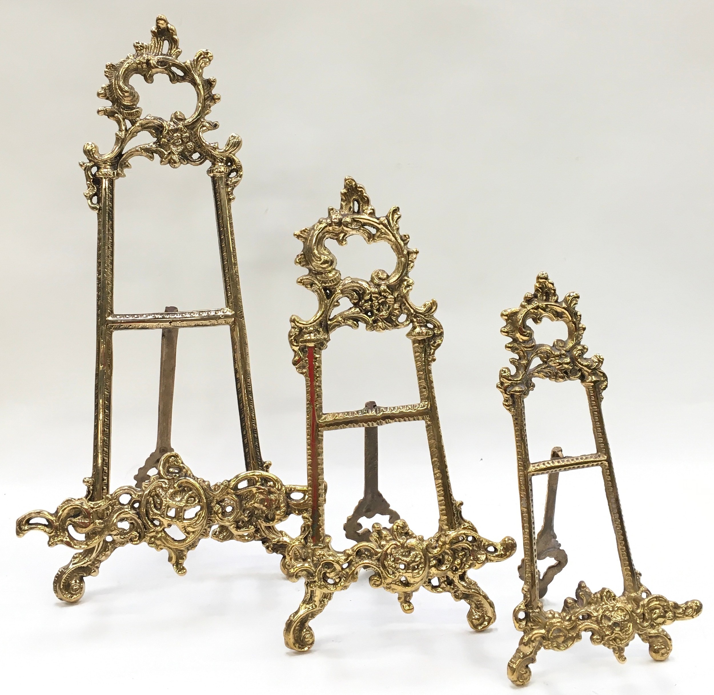 A set of three brass graduated easel back picture frame holders.