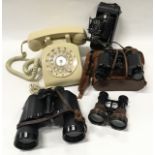 A vintage telephone, two pairs of binoculars, opera glasses and a vintage camera.