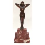 A bronze figure of a naked figure on a stepped marble base.