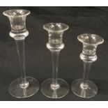 Three graduated Dartington glass candlestick holders the largest being 24cm tall.