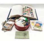 Stamp album with a quantity of loose stamps and postcards