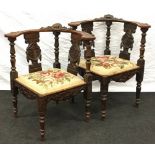 Heavily carved pair of corner chairs with tapestry fabric seats on turned supports having carved