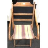 1920's oak folding chair with orange and brown striped fabric.