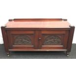 large oak two door sideboard on castors with carved decoration to doors. 59cm tall x 118cm wide x