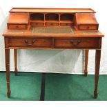 A ladies writing table with leather inserts, brass drop handles on tapered supports. 96x106x56 cms.
