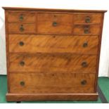Antique flame mahogany five over three chest of drawers featuring a central top hat drawer. O/all