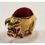 A brass pig pincushion
