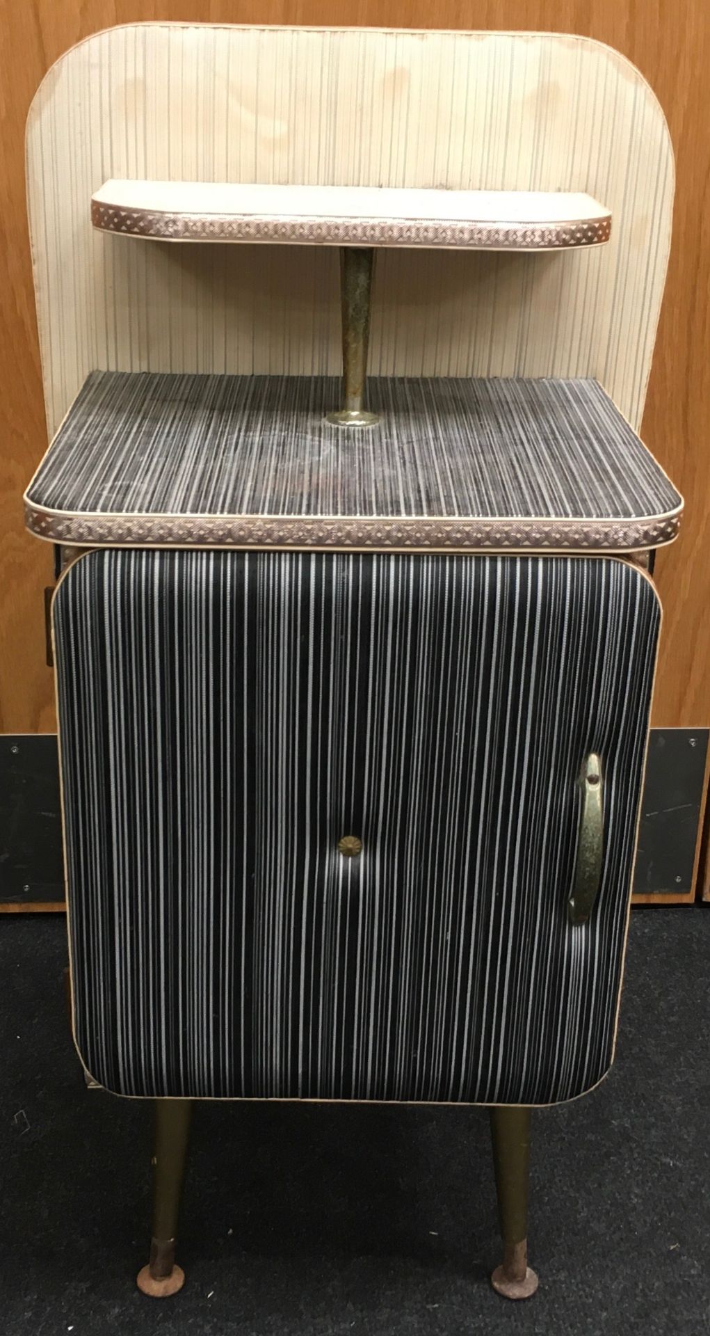 1950's padded vinyl bedside cabinet with single door cupboard and overshelf on tapered feet. O/all