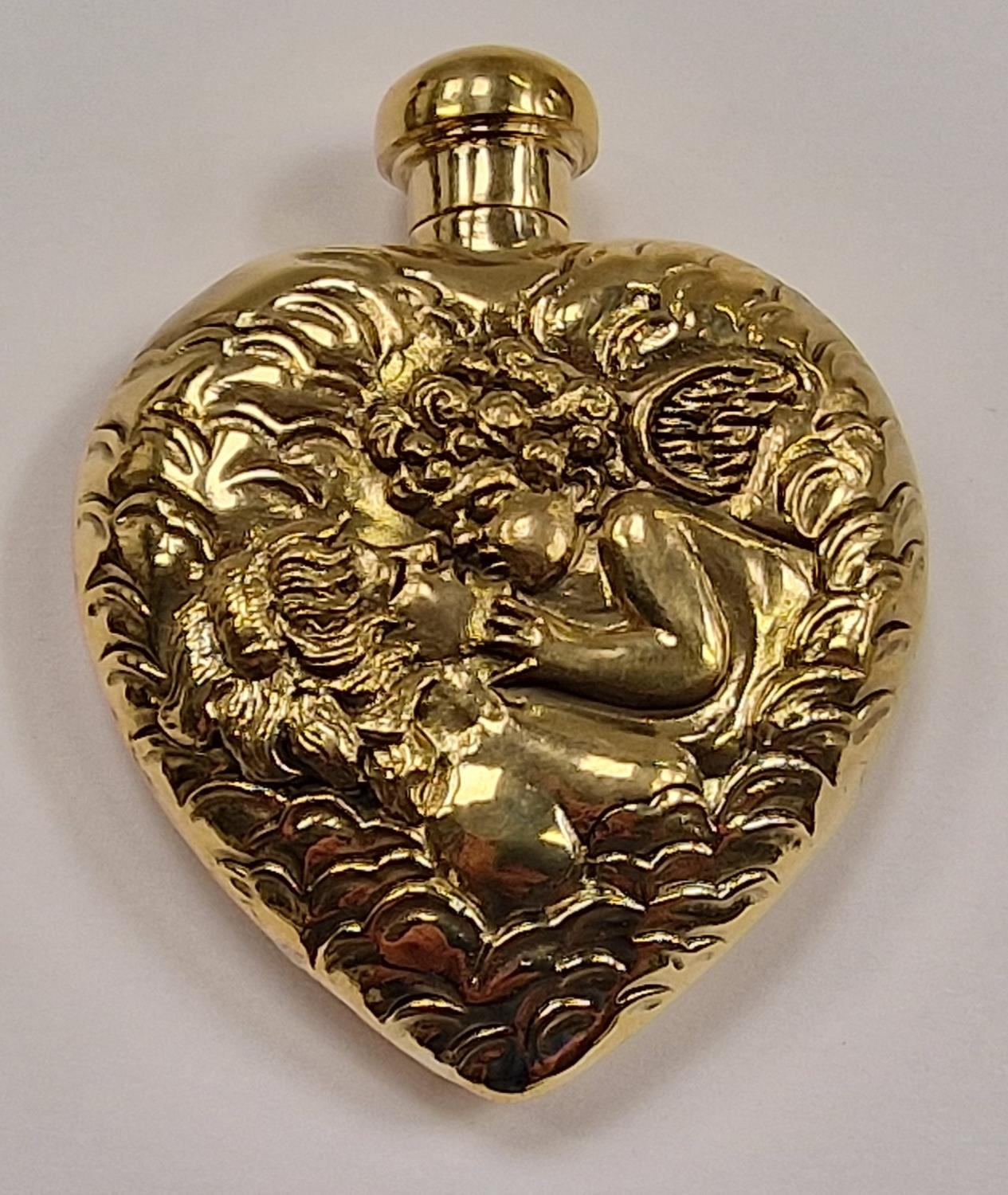 A brass perfume bottle with embossed decoration in the form of a heart.