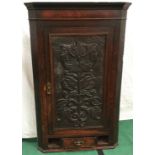 Antique oak wall hanging corner cupboard. single ornately carved door with three shelves within over