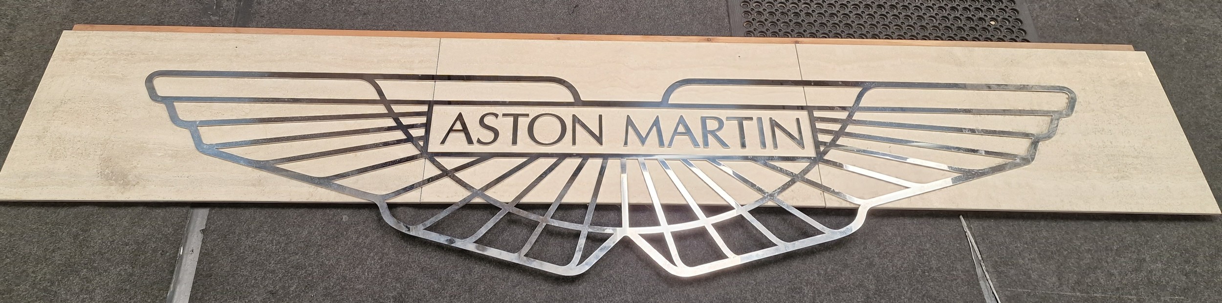 A Stainless steel Aston Martin exhibition sign mounted on slate board 300x72cm total size.