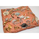 Large quantity of vintage costume jewellery brooches attached to a cushion