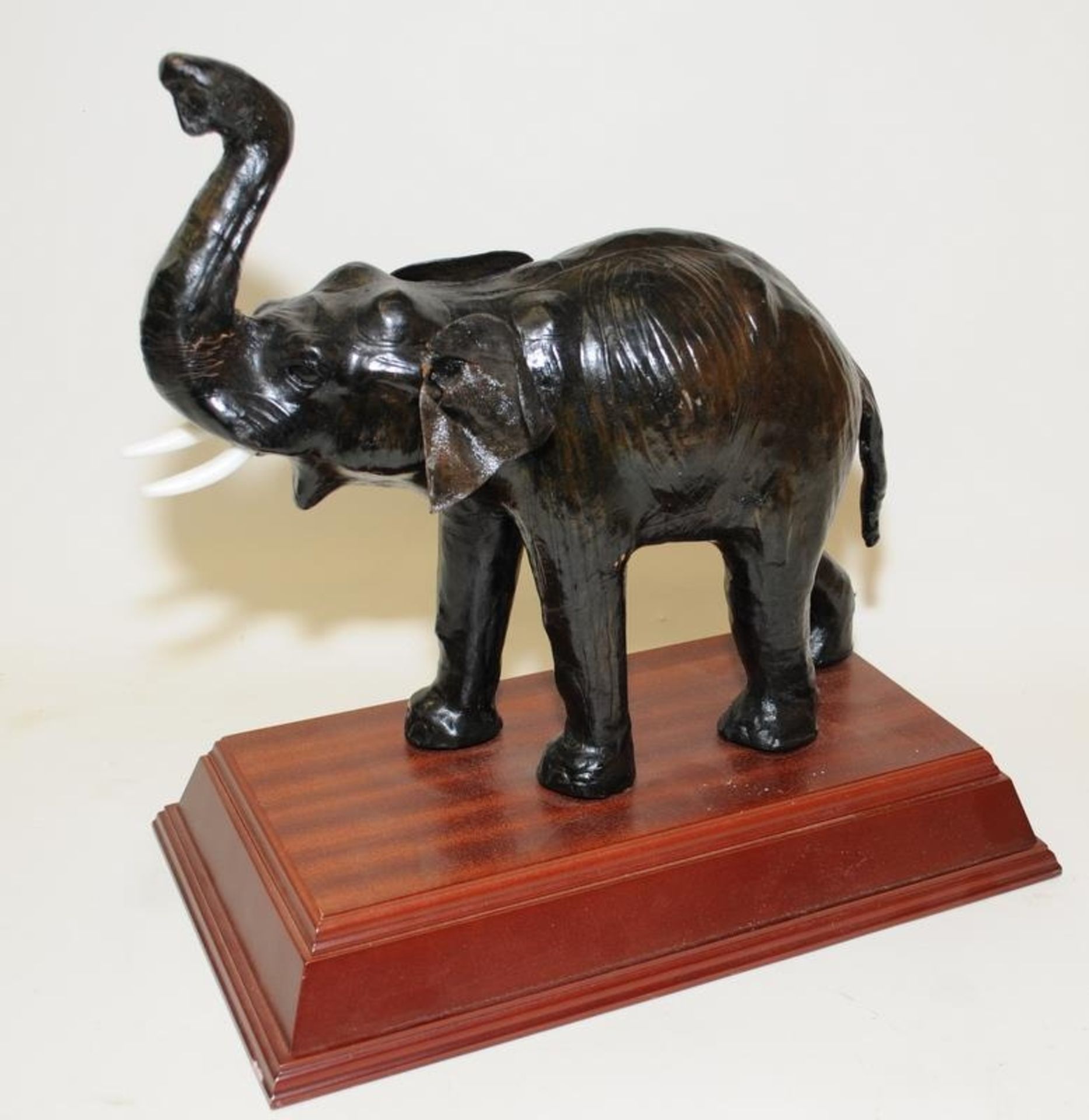 Vintage tooled leather over wood elephant mounted on a wooden plinth o/all height not including