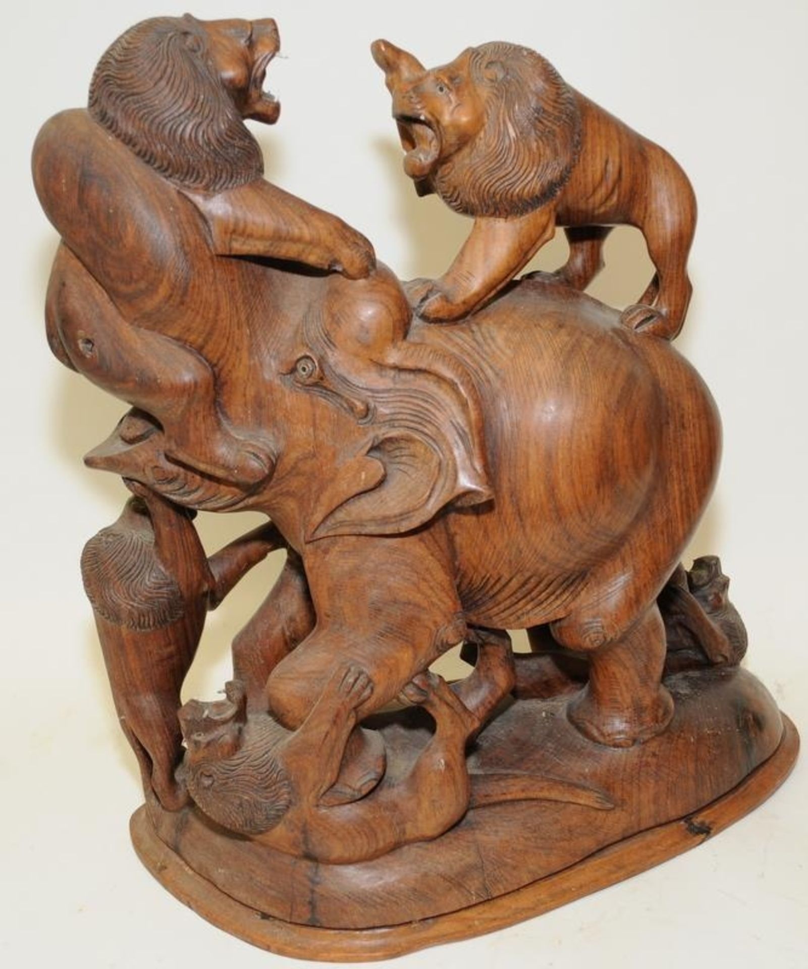 Very large wood carving depicting a bull elephant being attacked by five lions. 49cms tall