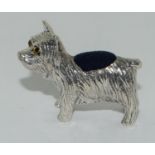 A Silver Dog pincushion with glass eyes.