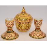 Three hand painted ceramics to include lidded bowl and candlesticks.