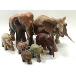 Collection of wooden and soapstone carved elephants to include two large examples. Largest stands