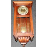 Vintage oak framed striking wall clock presented in working condition with pendulum and key. O/all
