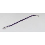 A silver CZ and amethyst line bracelet with snake head clasp.