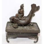 Vintage Chinese bronze figure of a man riding a carp sat upon a bronze plinth. possibly an opium