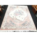 A room size Chinese carpet in beige and dusky pink with central panel depicting peacocks. O/all size