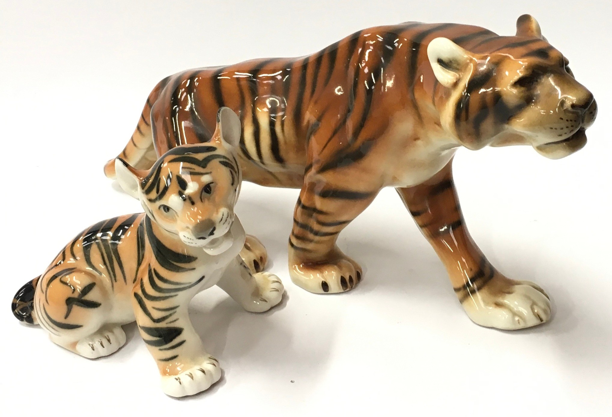 Two porcelain Czechoslovakian tiger ornaments. The largest measuring 17x40x9cm.