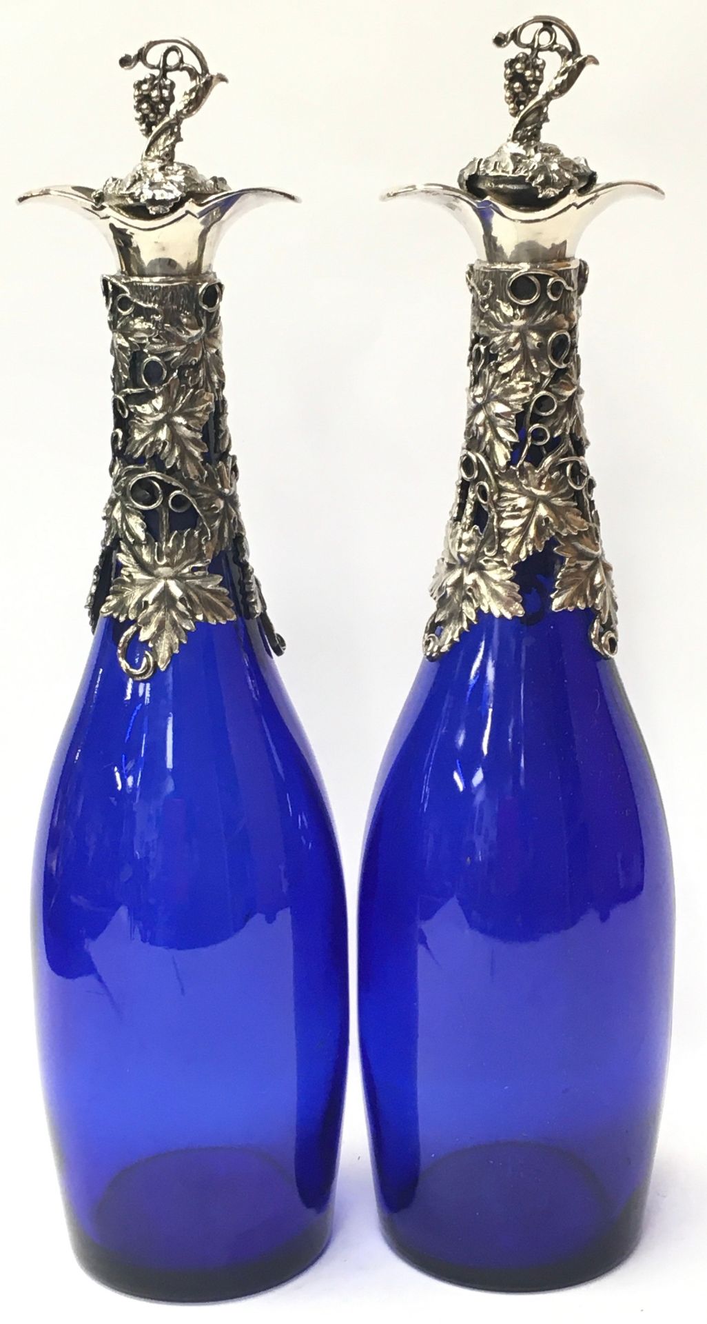 Pair of Bristol blue decanters with grape vine decoration to neck and stoppers