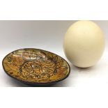 A collectible blown Ostrich egg c/w a presentation ceramic dish dated 1974