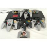 Nintendo 64 collection of two consoles with some controllers and games.