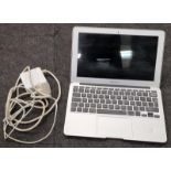 Apple MacBook Air laptop with power supply.