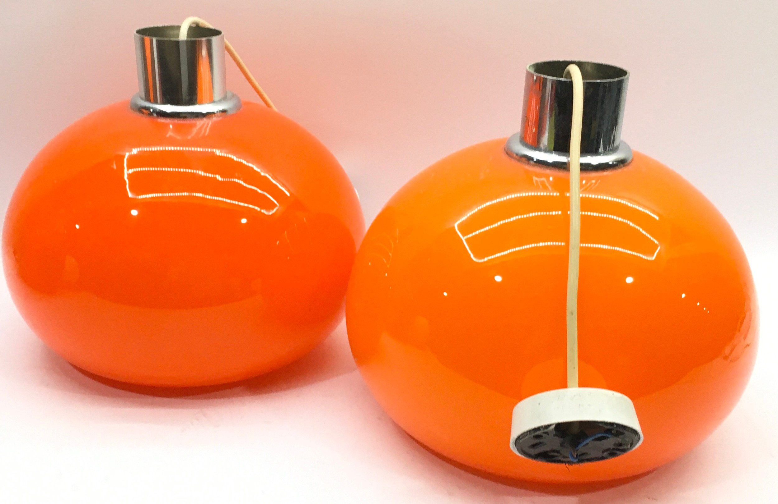 Pair of retro 1970's orange orb glass pendant lampshades with fittings. Approx 26cms tall and