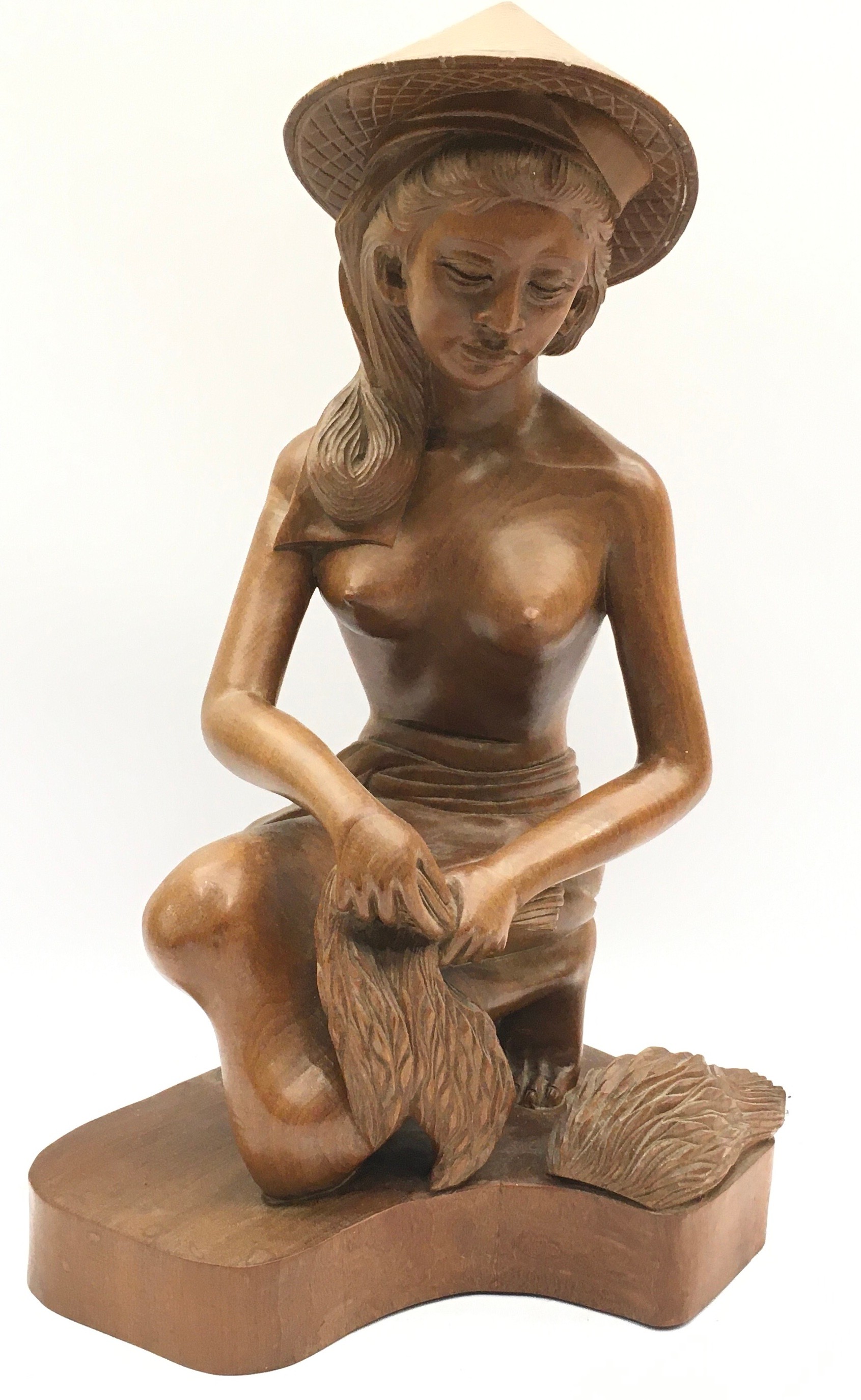 Wooden carving of an Oriental girl in traditional garb harvesting rice. 38cms tall