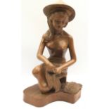 Wooden carving of an Oriental girl in traditional garb harvesting rice. 38cms tall