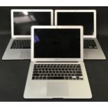 Three Apple Mac Book Air computers.