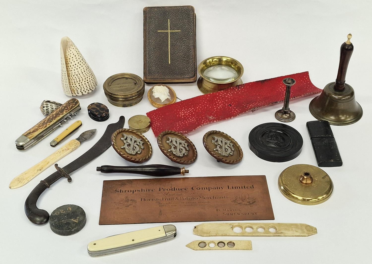 Mixed curios to include vintage lens, pen knives, vintage horse brass buckles, table bell etc