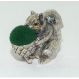 A silver squirrel pin cushion.