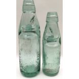A pair of antique green glass codd neck bottles with green stoppers, South Dorset Trades, Weymouth.